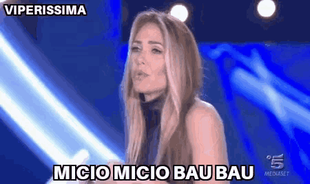 a woman is standing in front of a blue background and says " viperissima "