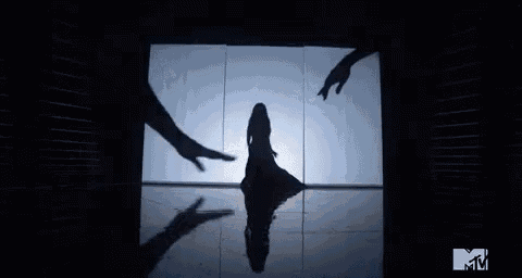 a silhouette of a woman dancing in front of a mirror .
