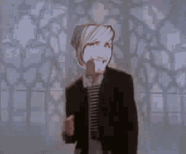 a man in a suit is singing into a microphone with his face visible