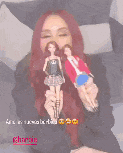 a woman with red hair is holding two barbie dolls in her hands with the caption amo las nuevas barbies