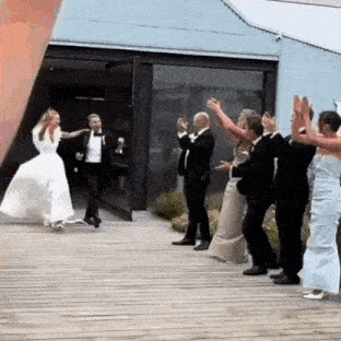 a bride and groom are being cheered by their wedding guests