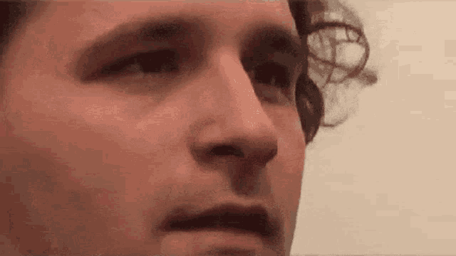a close up of a man 's face with curly hair making a face .