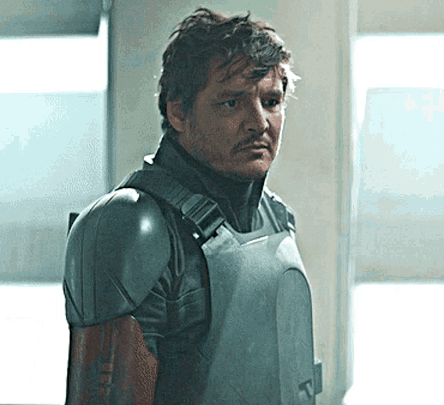 a man with a beard wearing a gray armored vest
