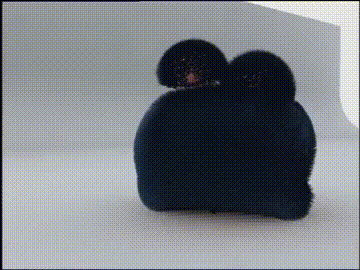 two black dogs are sitting on top of a black object .