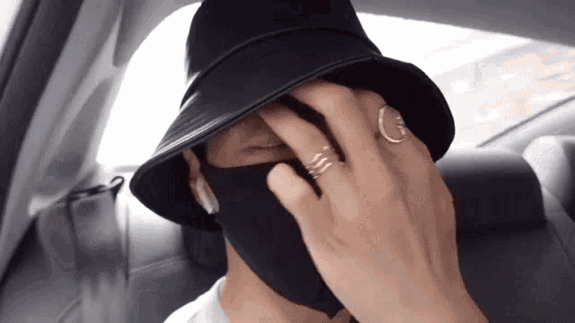 a man wearing a black hat and a black mask covering his face