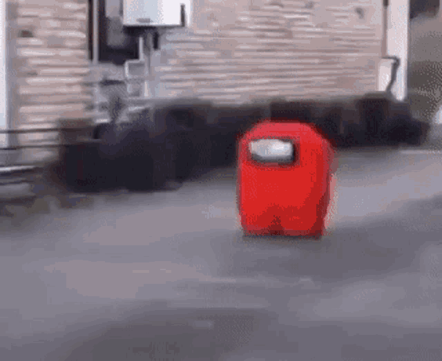 a red among us character is walking on the street .