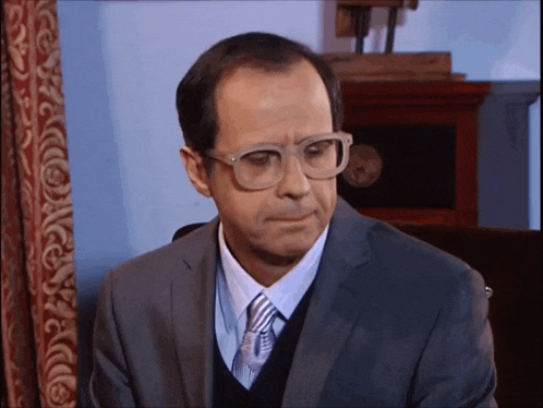 a man in a suit and tie with glasses on