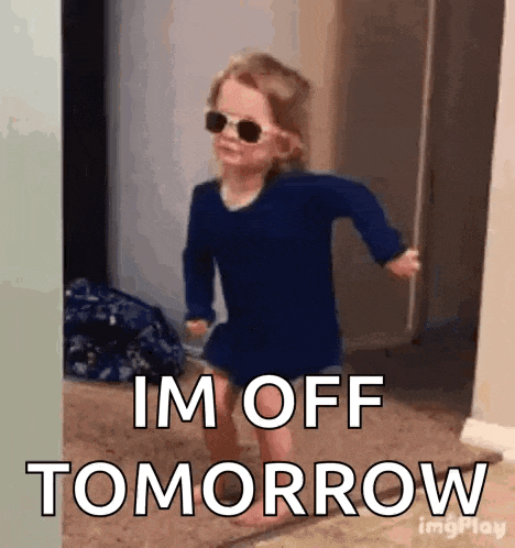 a little girl wearing sunglasses and a blue shirt is walking in a hallway .