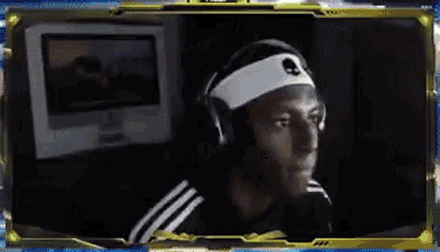 a man wearing headphones and a headband with a skull on it looks at the camera