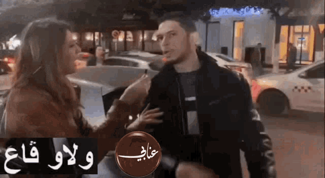 a woman is talking to a man in a parking lot in front of a car .