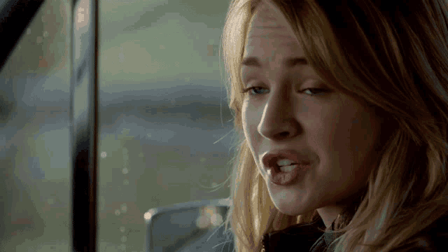 a close up of a woman 's face in a car with her mouth open