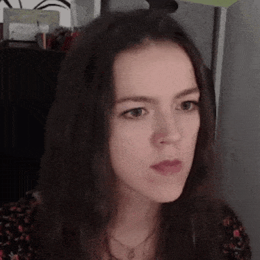 a close up of a woman 's face with a necklace on her neck .
