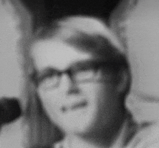 a black and white photo of a man wearing glasses and a headband .