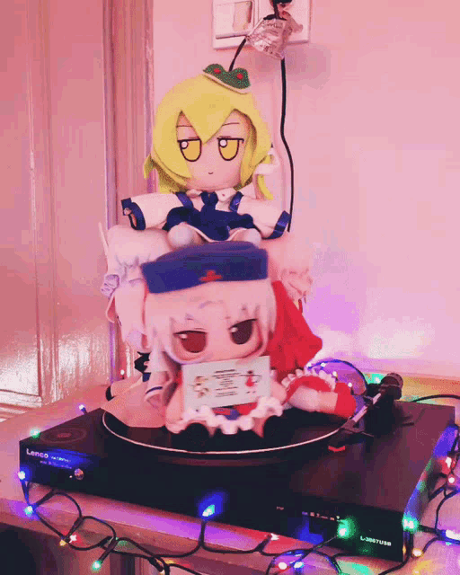 two stuffed dolls are sitting on top of a record player that says ' pioneer ' on it