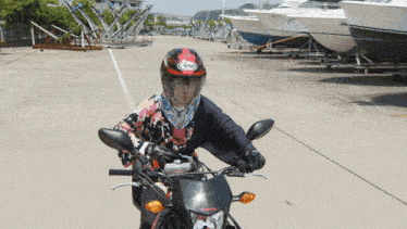 a person wearing an arai helmet is riding a motorcycle