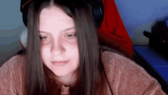 a young woman wearing headphones is sitting in a chair .