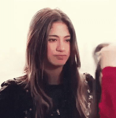 a woman with long hair is making a funny face while looking at the camera .