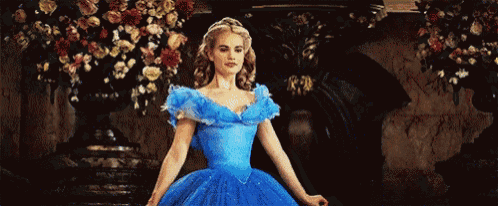 a woman in a blue dress is dancing in a ballroom .