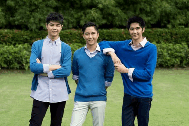 three young men in blue sweaters are posing for a picture together