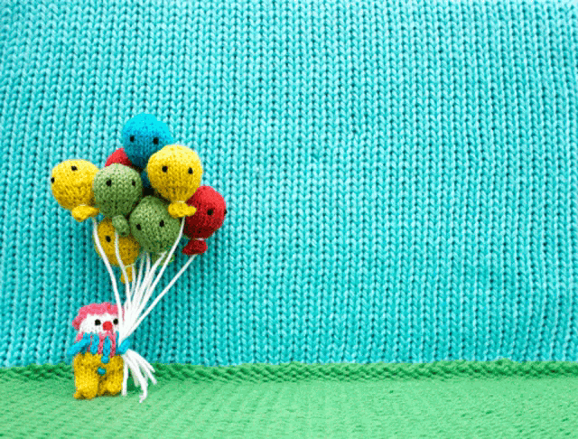 a stuffed animal holding a bunch of colorful balloons