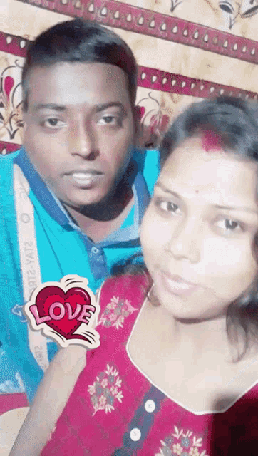 a man and a woman are posing for a picture with a sticker that says love on it