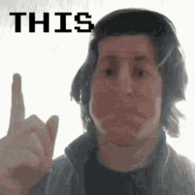 a man wearing headphones is making a funny face and pointing his finger at the camera .