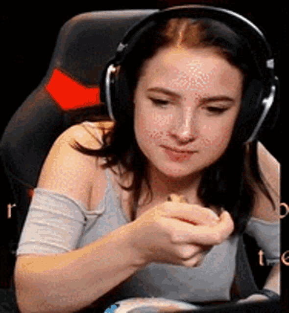 a woman wearing headphones is sitting in a chair eating food .