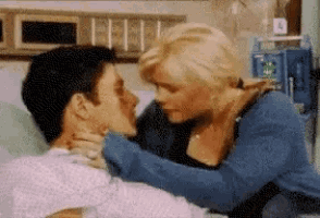 a man and woman are kissing in a hospital room .