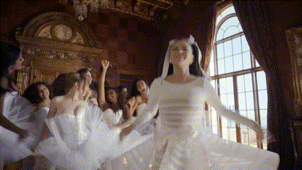 a group of women in white dresses are dancing in a room