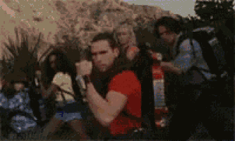 a man in a red shirt stands in front of a group of people with backpacks