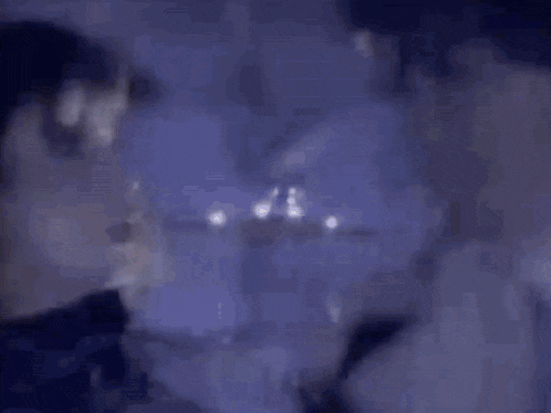 a man and a woman are standing next to each other and talking to each other in a dark room .