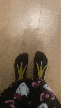 a person wearing a pair of black socks with chicken feet on them