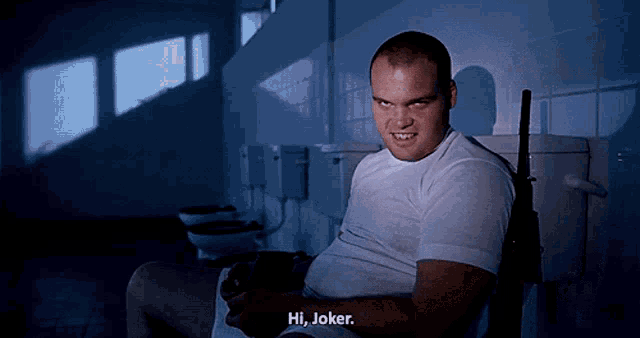 a man sitting on a toilet with the words hi joker written below him