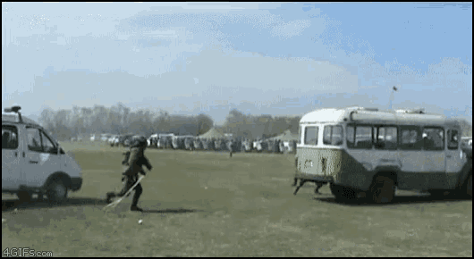 a green and white bus is parked in a grassy field