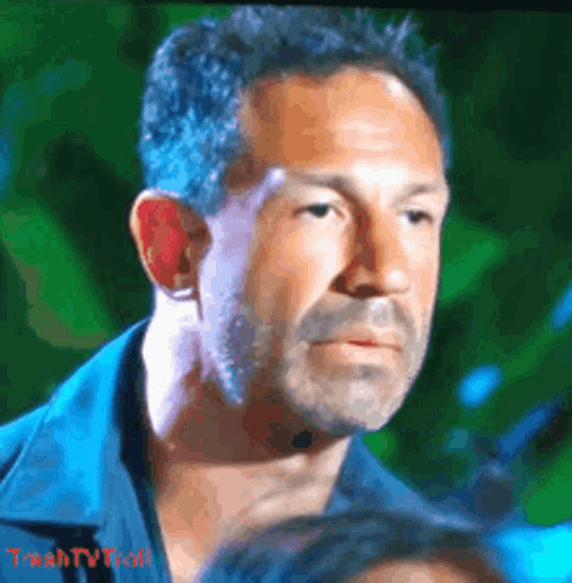 a close up of a man 's face with trash tv troll written on the bottom right
