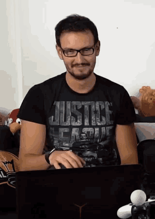 a man wearing a black justice league shirt