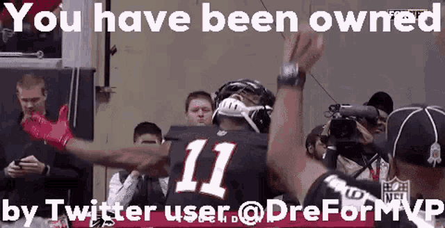 a football player with the number 11 on his jersey is giving a high five .