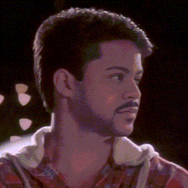 a man with a beard wearing a plaid shirt looks to the side