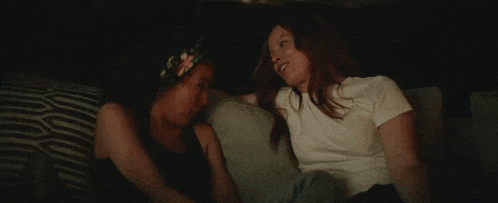 two women are sitting next to each other on a couch