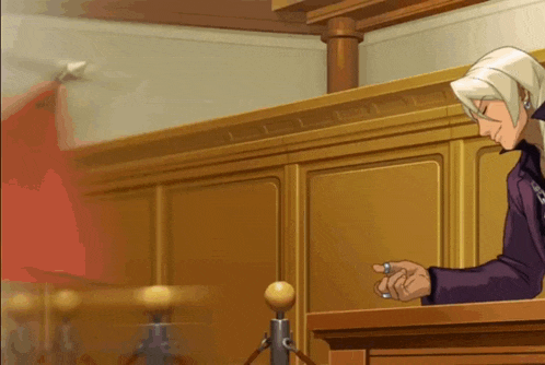 a man in a purple suit is sitting at a podium