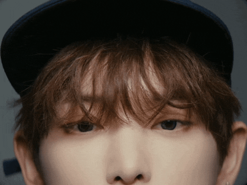a close up of a person wearing a hat and earrings