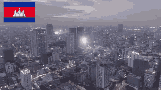 an aerial view of a city at night with the flag of cambodia in the foreground