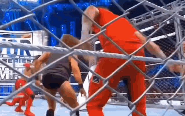 a wrestling match is being held in a ring with a chain link fence in the background .