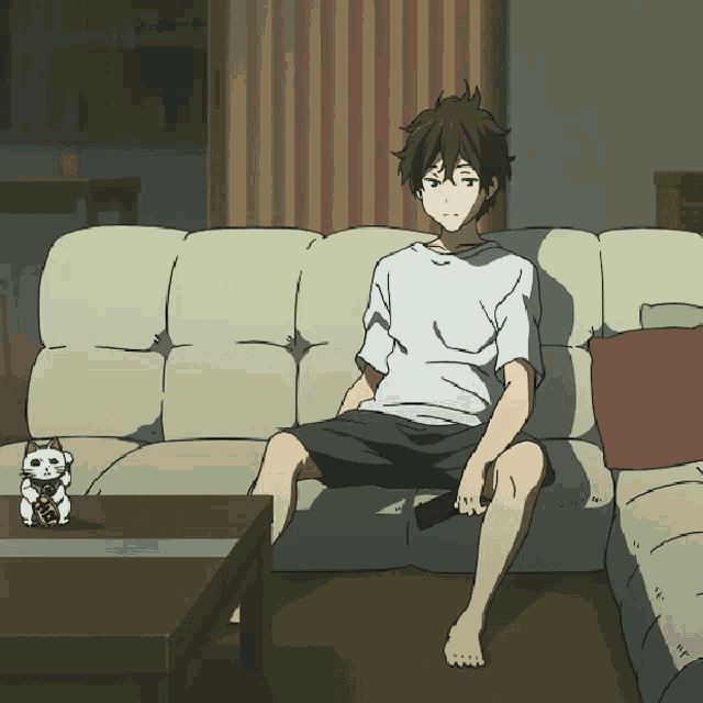 a man sits on a couch with a remote control