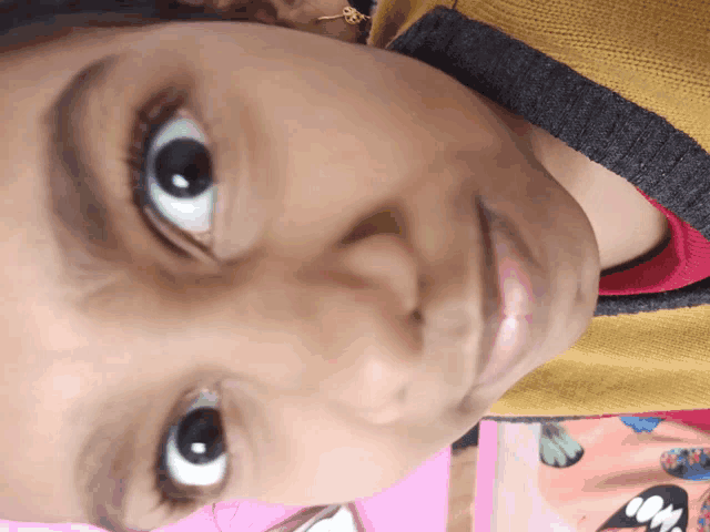 a close up of a child 's face with a yellow sweater