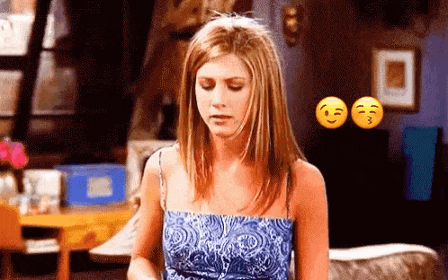a woman in a blue dress is sitting on a couch in a living room with two smiley faces behind her .