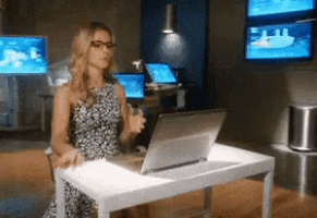 a woman is sitting at a desk with a laptop
