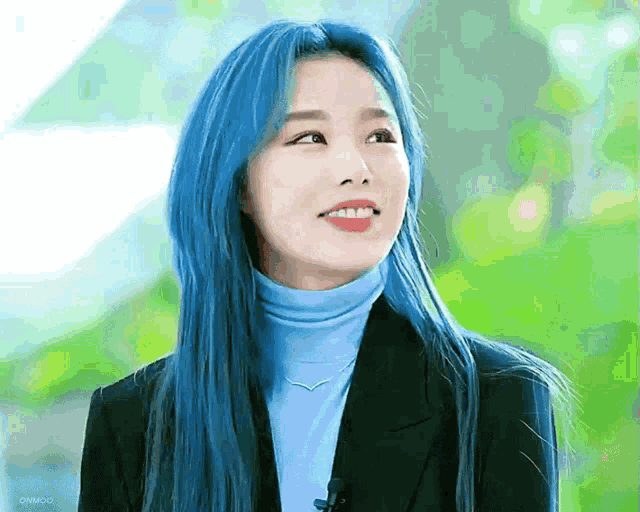 a woman with blue hair wearing a blue turtleneck and black jacket