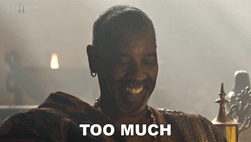 a man with a beard is smiling with the words too much above him