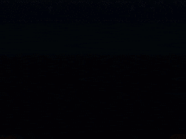 a close up of a glowing object in the dark with a dark background